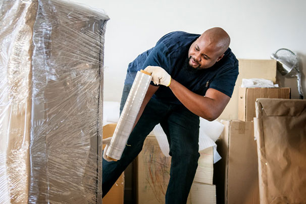 man wrapping item with stretch film